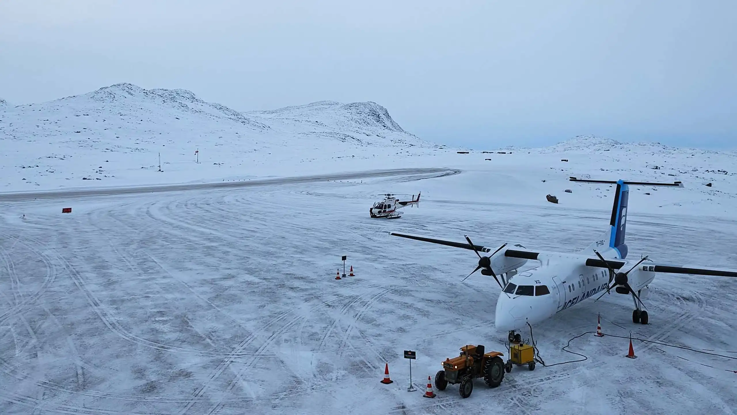 Icelandair Dash-8 FI103 landed 11.51 a.m in Kulusuk. Greenland Copter waiting for the pilot Photo: Jesper Nymand, AFIS i Kulusuk