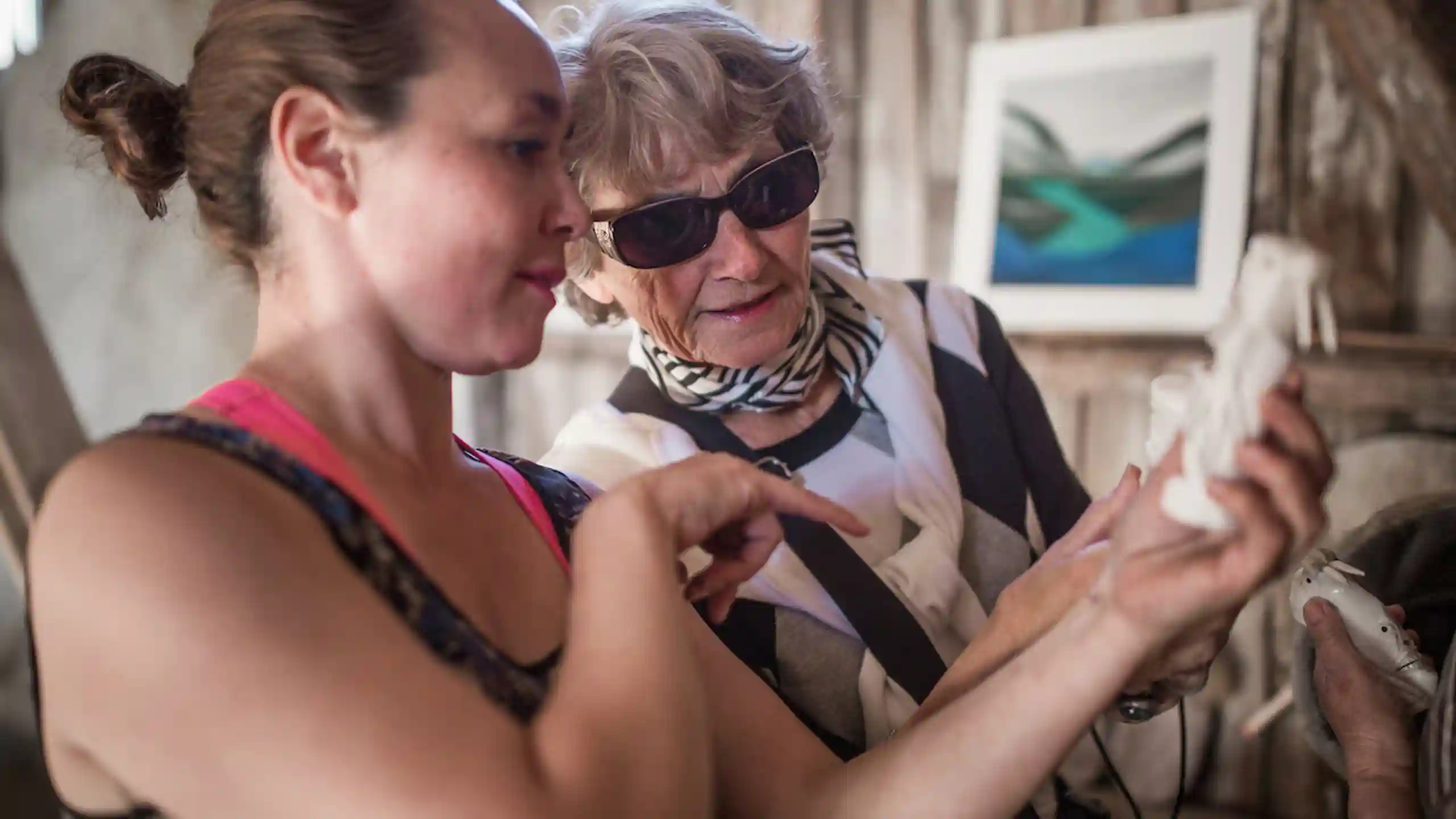 Kattie From Hotel Narsaq Telling A Guest About A Tupilak Bone Carving From Narsaq In South Greenland