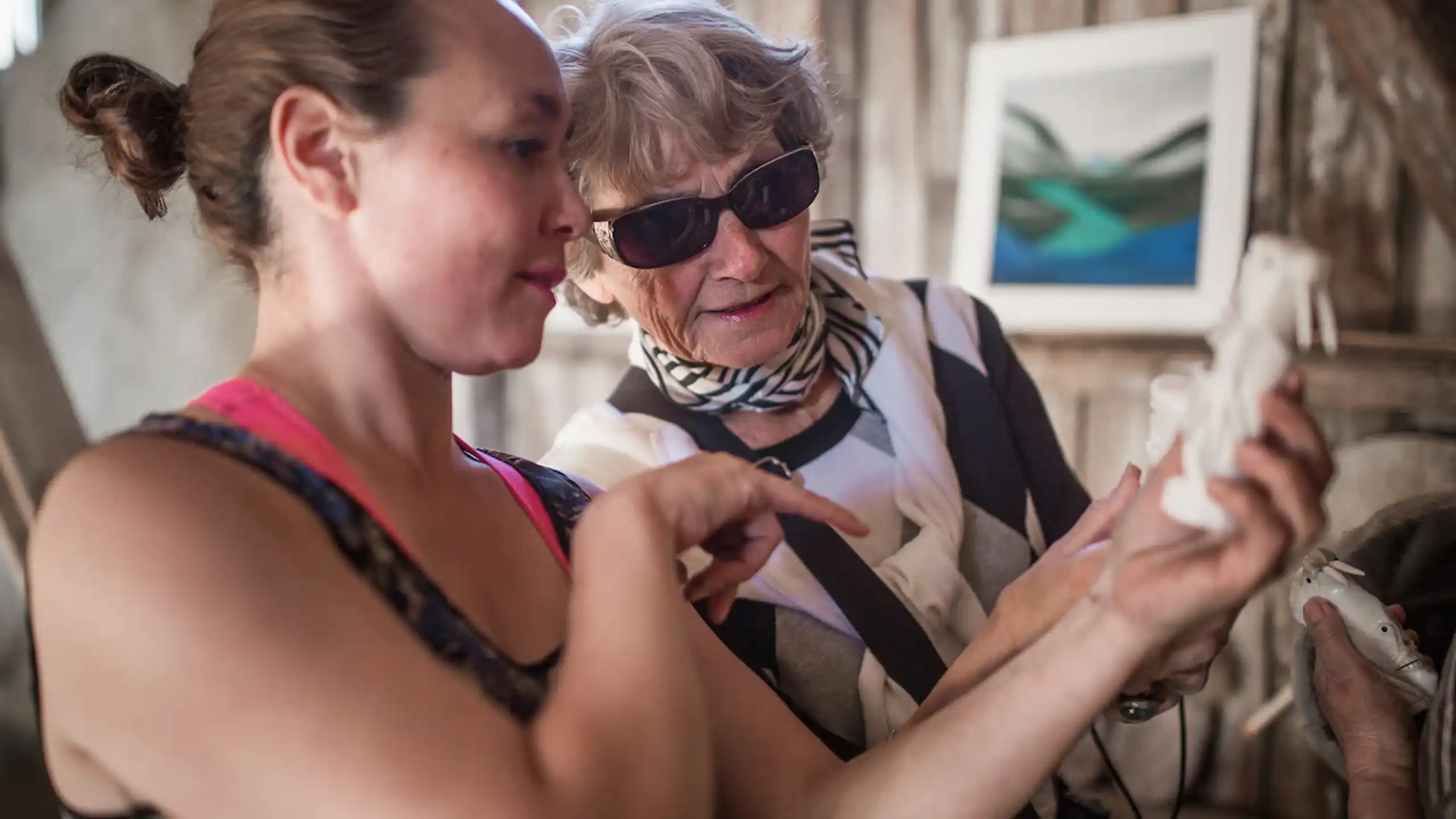 Kattie From Hotel Narsaq Telling A Guest About A Tupilak Bone Carving From Narsaq In South Greenland