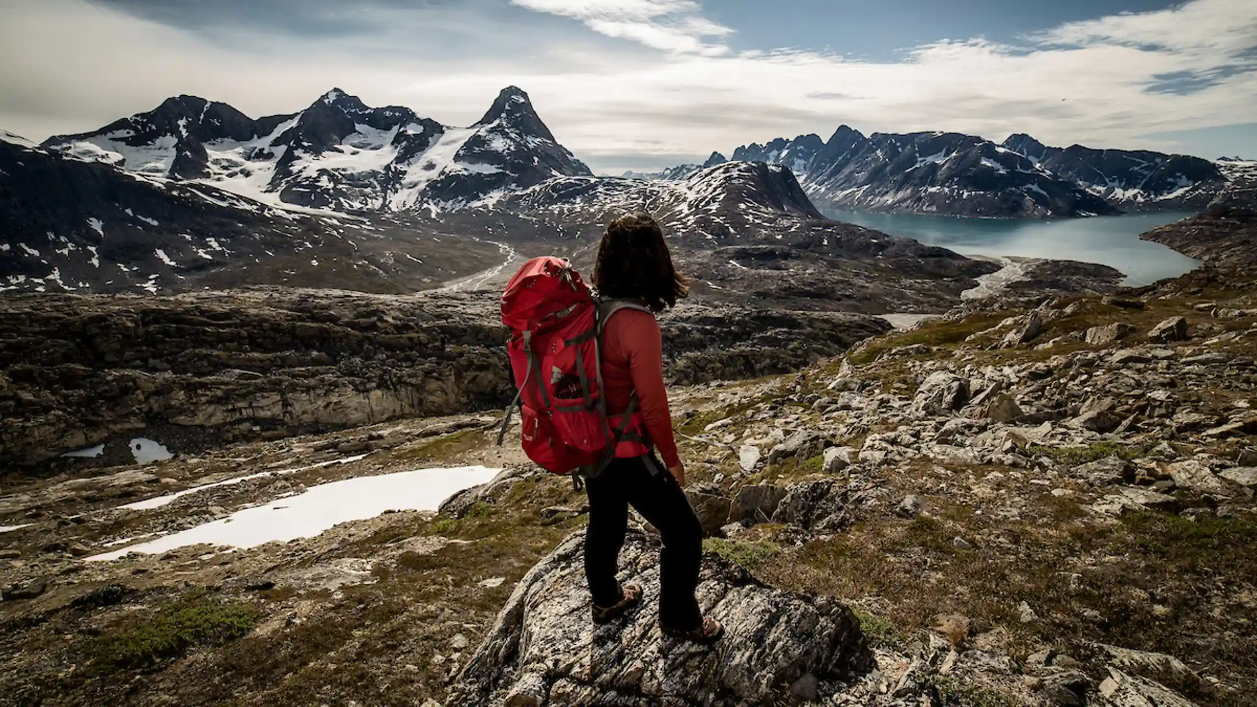 A Hiker Looking Towards Tasiilaq Island In East Greenland