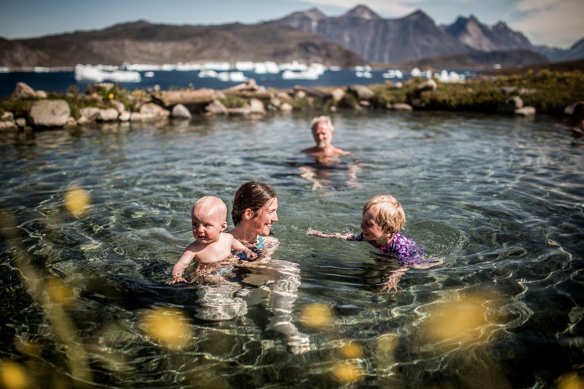 A Family Swimming In The Uunartoq Hot Springs In South Greenland