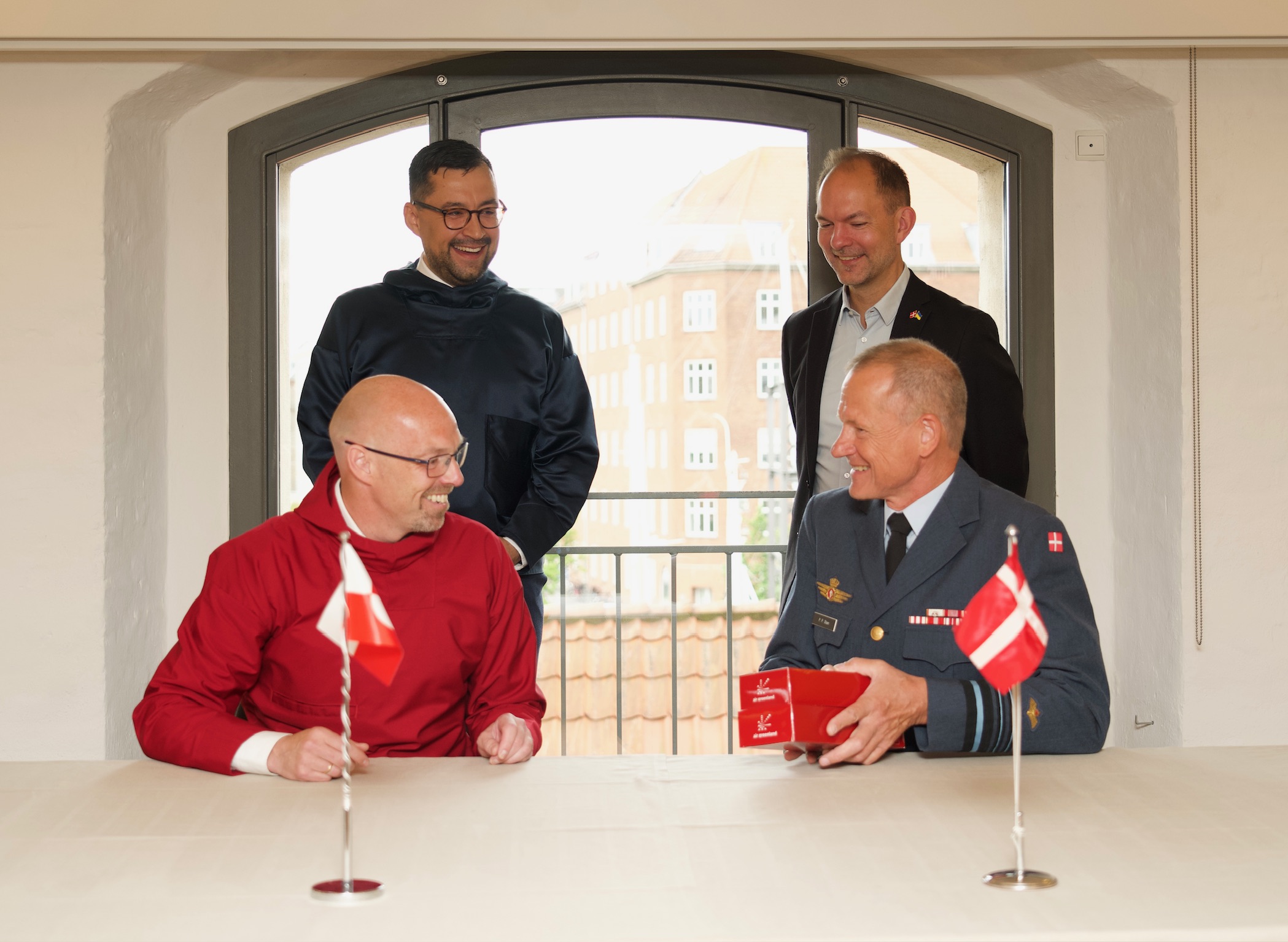 Tallimanngornermi 3. juulimi Nordatlantens Brygge-mi Københavnimiittumi Kalaallit Aallartitaqarfianni Air Greenlandip suliffeqarfissuani pisortaanerup Jacob Nitter Sørensen-ip aamma Illersornissaqarfimmi Atortunut Pisiniartarnermullu Aqutsisoqarfiup pisortaata generalløjtnant Per Pugholm Olsen-ip MDA-mut isumaqatigiissut atsiorpaat. Ass.: Forsvarsministeriet